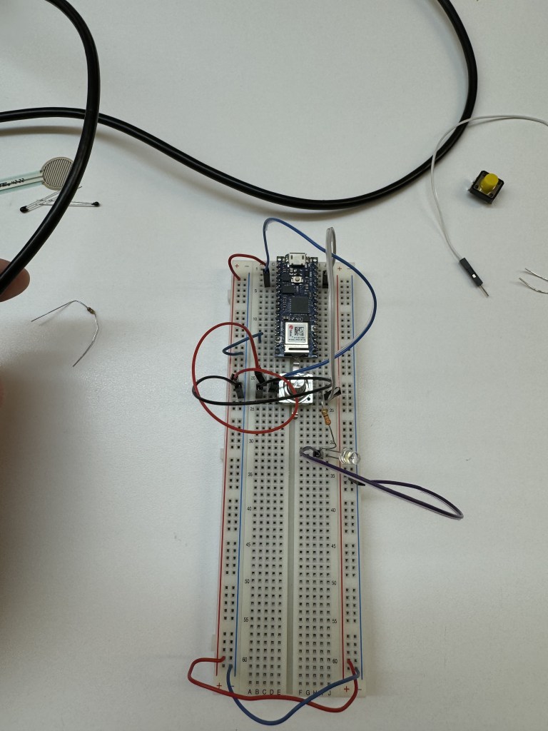 Arduino on breadboard with potentiometer and a white LED.